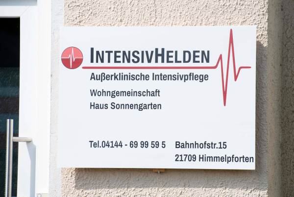 Schild mit Adresse an der Eingangstür