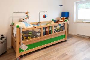 Ein elektrisch verstellbares Kinderbett mit vielen Plüschtieren